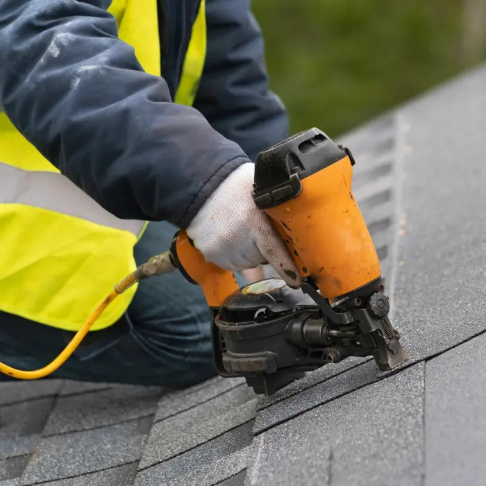 Person using nail gun roofing