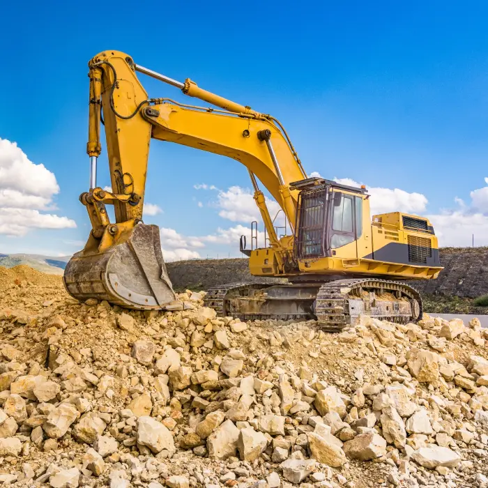 Yellow excavator on rocky terrain