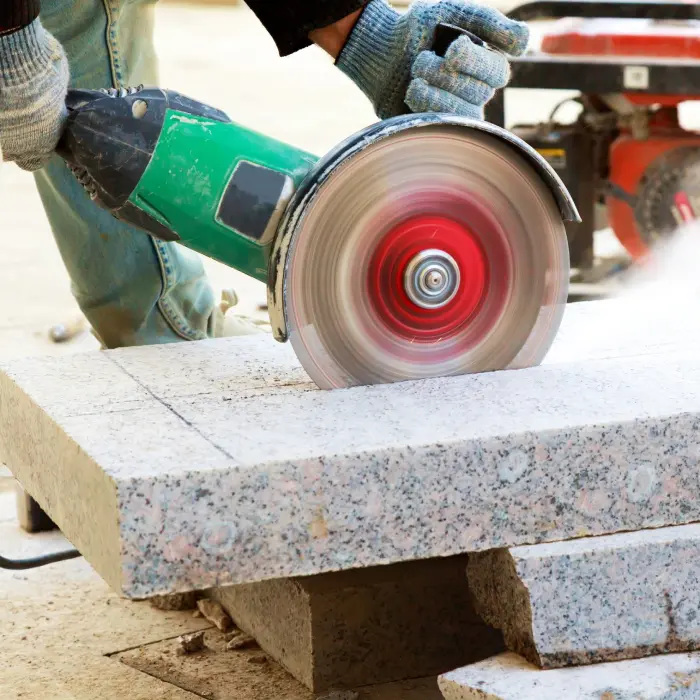Worker cutting stone with saw